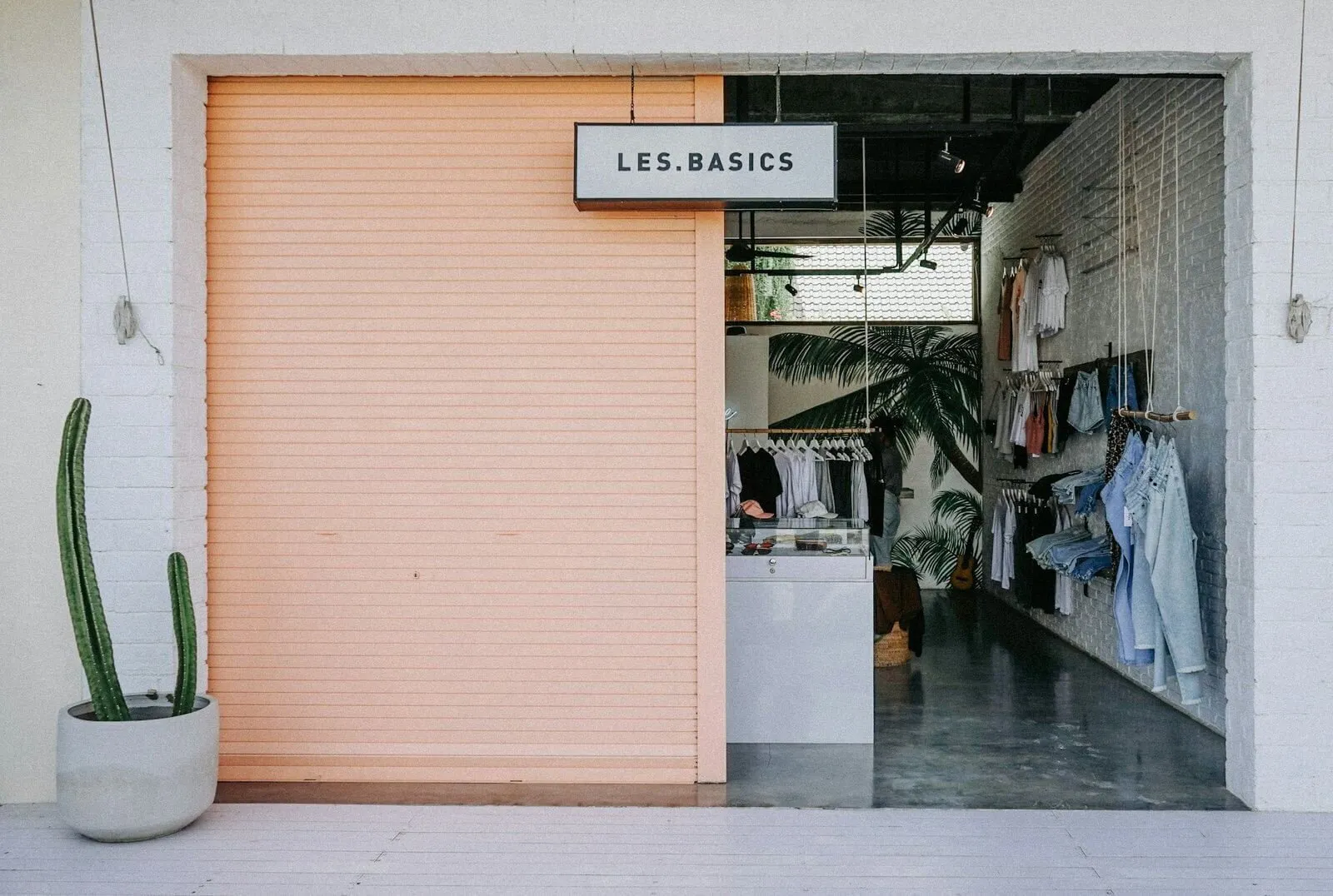 Devanture d’une boutique de prêt-à-porter, portants de vêtements visibles à l’intérieur