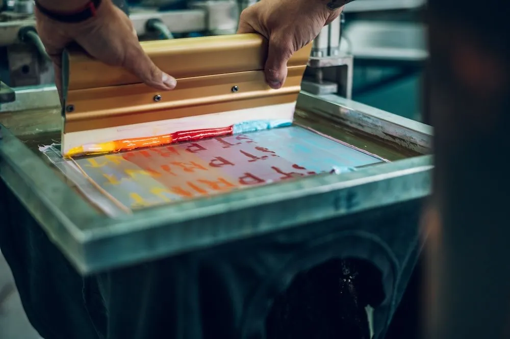 Sérigraphie : passage de l’encre au racloir sur un cadre